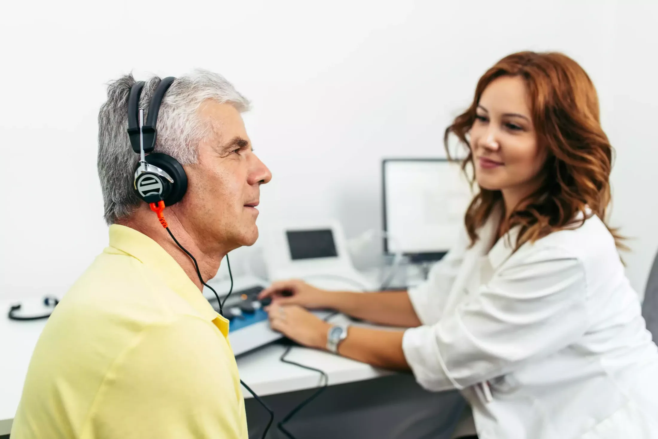 Patient équipé d’un casque pendant un examen audiométrique avec une audiologiste
